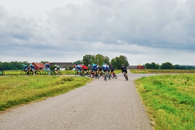 People on the road during the day to ride a bicycle
